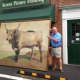 Geary Gallery owner Tom Geary stands with his latest big project, a framed 7 x 9-foot oil painting.