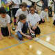Sixth-grade Country School student Sarah Gallagher programs her robot to walk the plank without falling off in a pirate-themed robotics competition. Teammates Jessica Cramer, Jack Ferm and Bo Zeigler lend support.