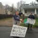 Protesters wave signs in front of the Fairfield home. 