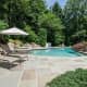 The neatly landscaped backyard includes a stunning pool. 