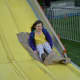 Eight-year-old Maya Bartlett, Pound Ridge, goes on a large slide at the St. Patrick's carnival in Bedford.