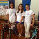 Cristiana (left) and Lucia Villani (center) and their mother Adriane Defeo (right) help give away bikes to kids.