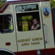 A girl riding in a Mount Kisco firetruck waves.