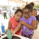Children have fun with spin art at Cross County Shopping Centers SummerFest celebration.