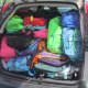 A van is packed with all the backpacks. 