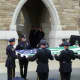 Police engage in a flag folding ceremony following the placement of Michael Williams' casket into a hearse. 