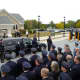Visiting police stand towards the hearse containing Michael Williams' casket outside of a LaGrangeville church.