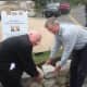 Westport First Selectman Jim Marpe and Sam Gault of Gault Energy and Stone lay the capstones of the fieldstone wall around the Minute Man Monument.