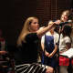 Pocantico School Music Director Sheila DePaola adjusted the microphone for a singer.
