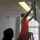 Andre Campbell installs the new energy-efficient light fixtures in City Hall.