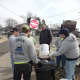 The group empties garbage theyve picked up into large trash cans.