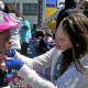 A volunteer fits a child with a new bike helmet.