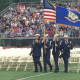 Members of the AFJROTC carry flags in to the football field at Norwalk High School Thursday.