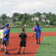 Mookie Wilson explaining proper fielding techniques to A-Game Sports campers in New Rochelle.