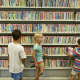 Kids look at DVDs for sale at the Westport Library.