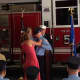 New Wilton Firefighter John Edwards gets his badge pinned by his wife and daughter.