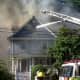Firefighters attempt to extinguish an Elmsford fire that destroyed one home and jumped to the next on Woodside Avenue in June.