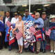 Christie Ruiz of Christie's Quilting Boutique, front, with flag, stands with veterans who received quilts on Saturday.