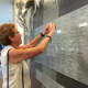 Patricia Mansfield of East Lyme photographs the plaque for her brother Timothy John "T.J." Hargrave. 