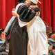 A students gets a diploma and a hug.