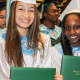 Two students holding up their diplomas.