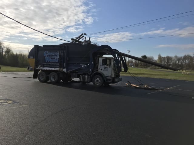 The driver of a county garbage truck distracted by a noise crashed into a utility pole.