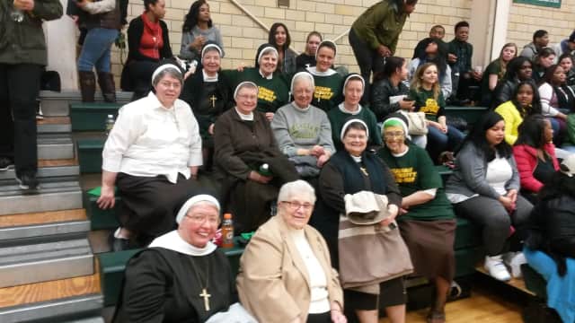 The Felician Sisters show their support for the Felician University basketball teams with both cheers and prayers.