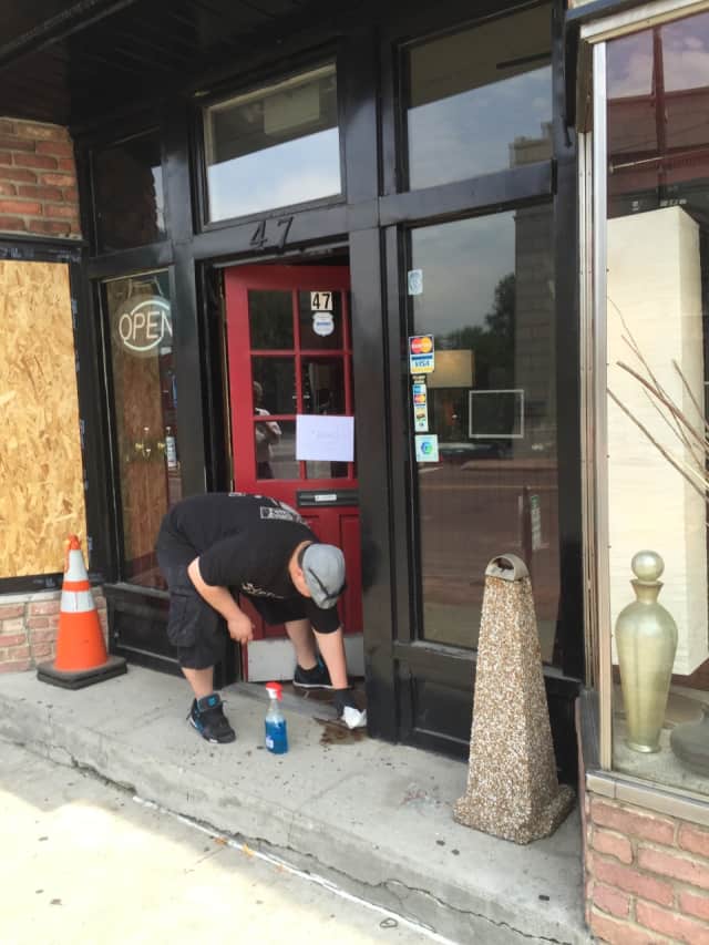 Man cleaning up blood Monday afternoon at the Ink Side Out tattoo shop on Wall Street in Norwalk.