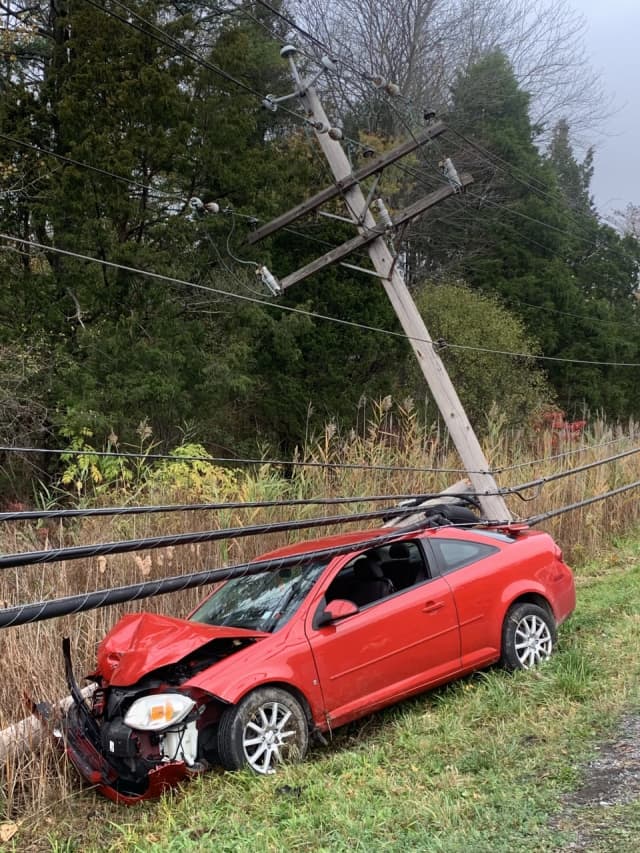 A woman was pinned in her vehicle under live power lines following a crash.