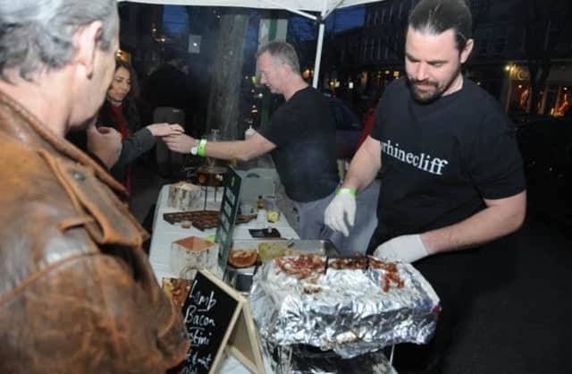 James Chapman, center, and Dale Andrews, right, from The Rhinecliff Hotel serve lamb and bacon crostini during this year's Taste of Rhinebeck.