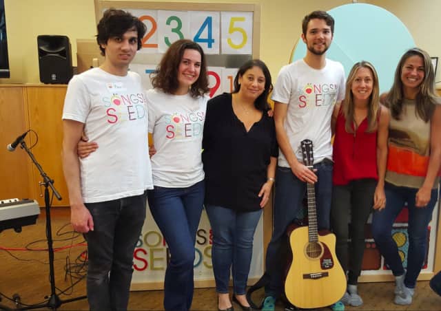 Dana Fisher, in middle in black blouse, with band and Songs for Seeds NYC founders.