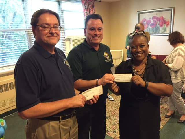 Greg Matera and George Ribellino from Knights of Columbus present checks to Lucy Freeman, executive cirector of Malta House