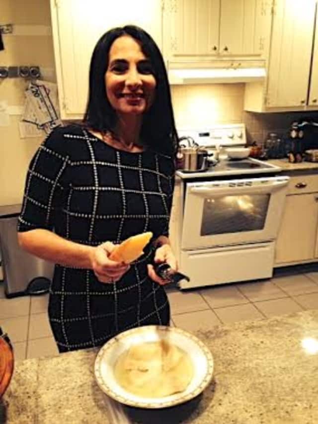 Doreen Goldstein grating parmesan over her cappelletti soup.
