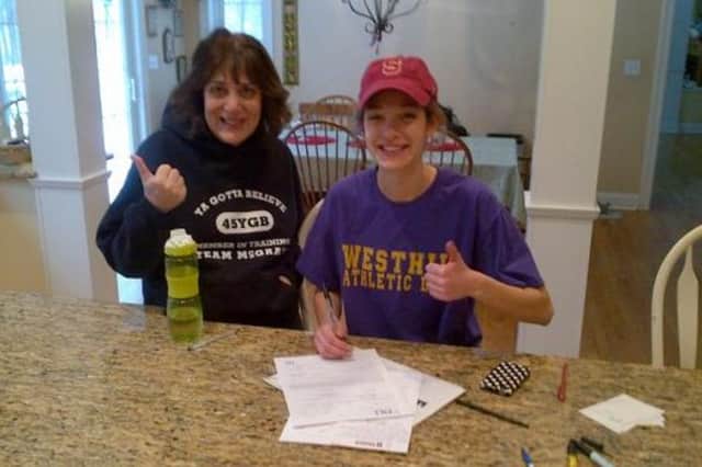Westhill senior Claire Howlett signs her letter of intent to Stanford University as her mother, Lisa, gives her approval.