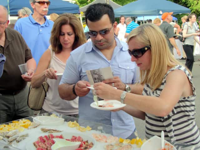 People try samples of food during a past year's Taste of Wilton event.