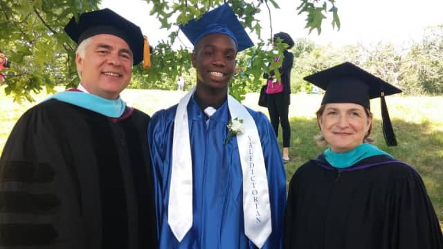 Orchard School Principal  Raymond Effinger and President and CEO Mimi Clarke Corcoran flank Tarik, one of two valedictorians of the Class of 2014.