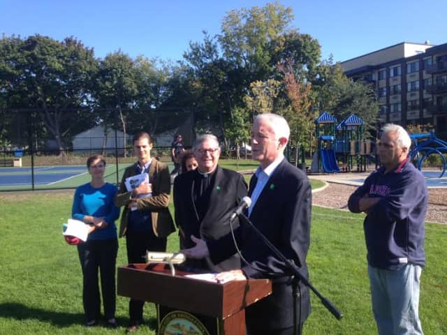Mayor Bill Finch, the Rev. Jefferey P. von Arx, and staffers from Fairfield University and the City of Bridgeport discuss a new parks economy study at Ellsworth Field on Monday. 