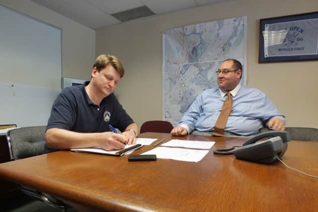 Mamaroneck Village Manager Richard Slingerland and Assistant Village Manager Dan Sarnoff sit at Town Hall, where a FEMA flood map of Mamaroneck stays on the wall.