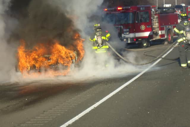 Norwalk firefighters fight a car fire on I-95 south in Norwalk Thursday afternoon.