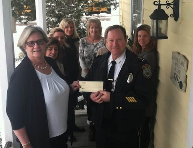 Wilton Police Department Interim Chief Robert Crosby accepts a $5,000 check from Realty Seven owner-broker Peg Koellmer. The money will be used to buy six body cameras for the department.