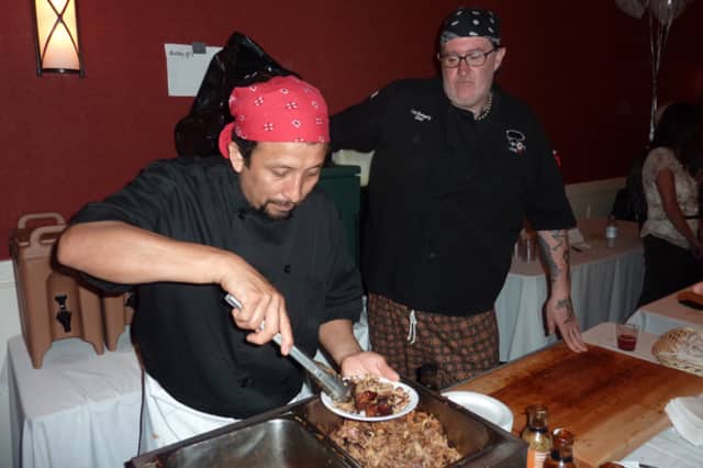 A cook from Bobby Q's prepares a plate of food for a guest at the 2015 Taste of Westport event at the Westport Inn. This year's event will be May 5.