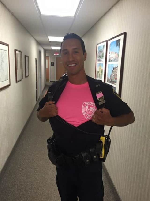 Ossining Police are selling a limited quantity of their pink department shirts, as displayed by Police Officer Addison Chavez. 
