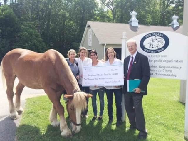 Sara Tucker, Nicole Konaman, Stacy Gendels and Caroleigh Evarts of New Canaan Mounted Troop are presented with a $2,500 grant from First County Bank Foundation by David VanBuskirk. Five other New Canaan nonprofits were awarded grants as well.