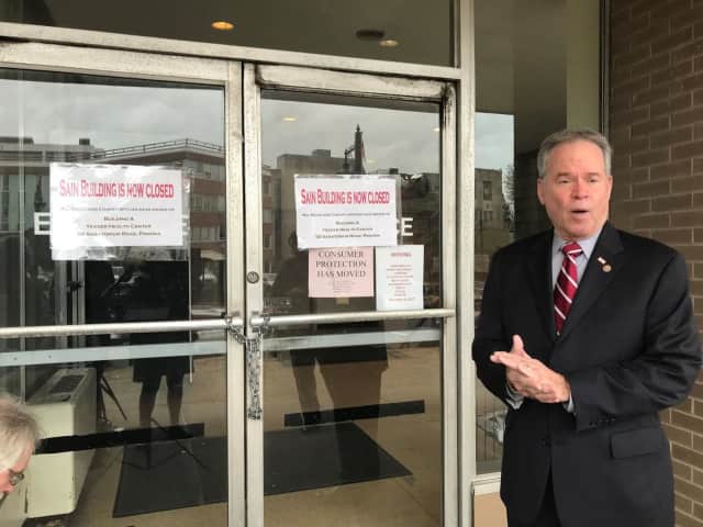 County Executive Ed Day standing in front of the now-closed Sain Building.